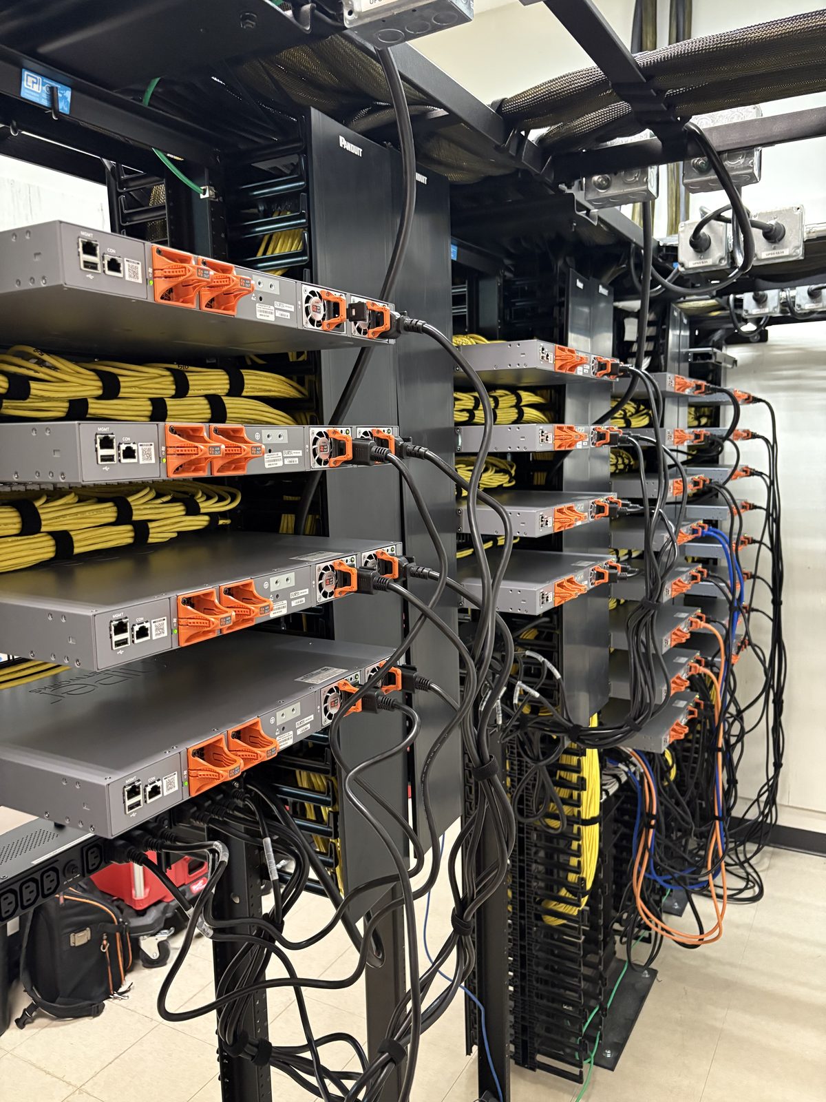 Rear of Juniper EX4100 switch stack with combed yellow patch bundles