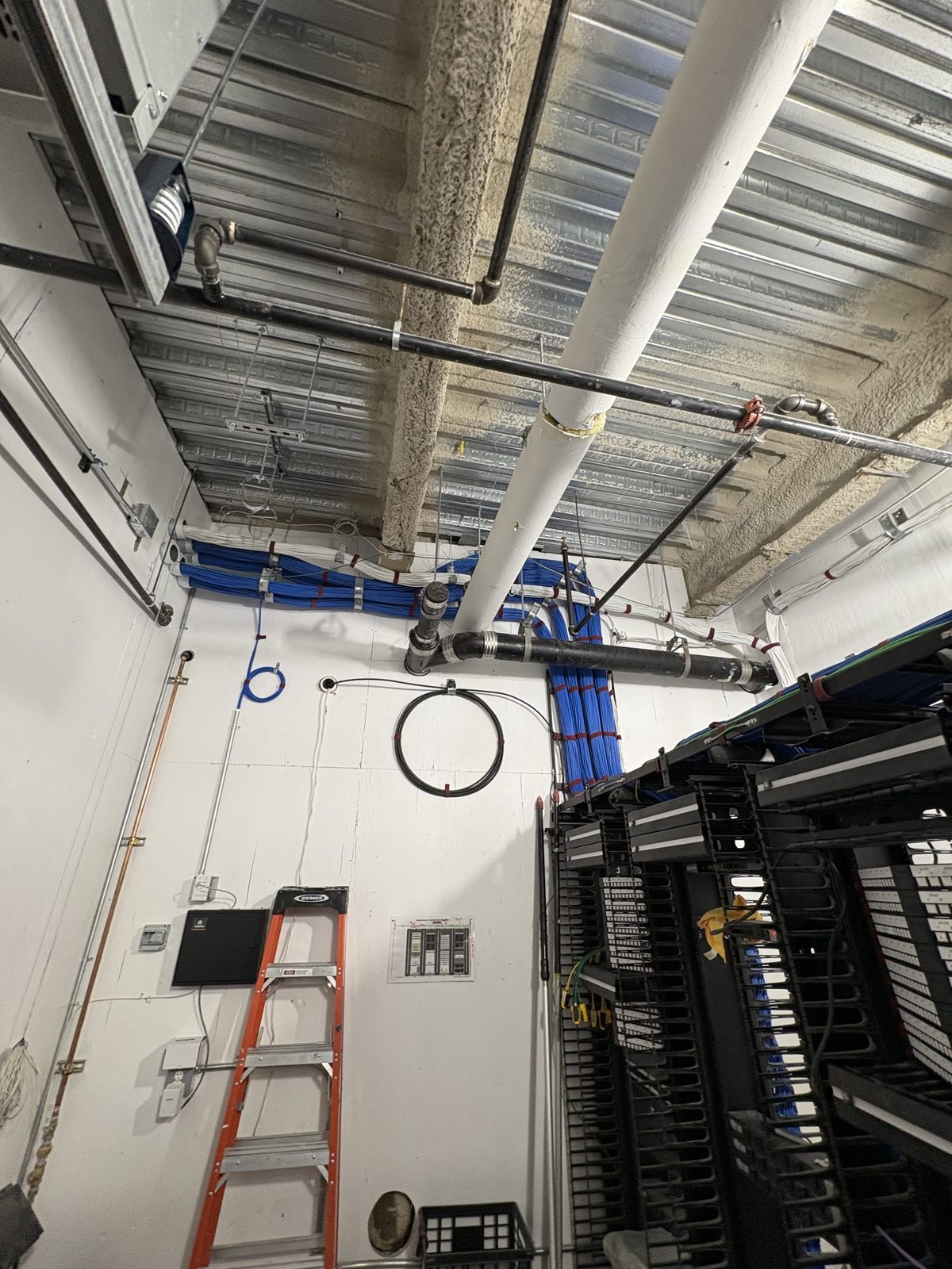Overhead blue cable pathway across a server room
