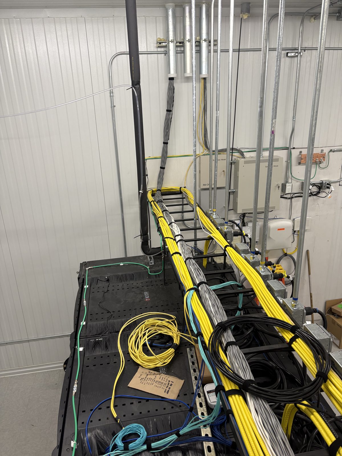 Overhead ladder rack run with combed yellow and gray cable bundles