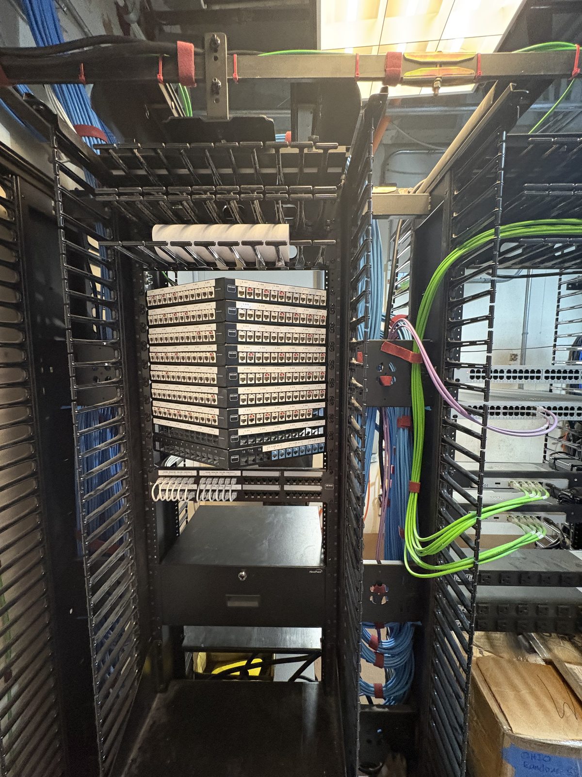 Front-facing patch panel stack with green and blue patch runs
