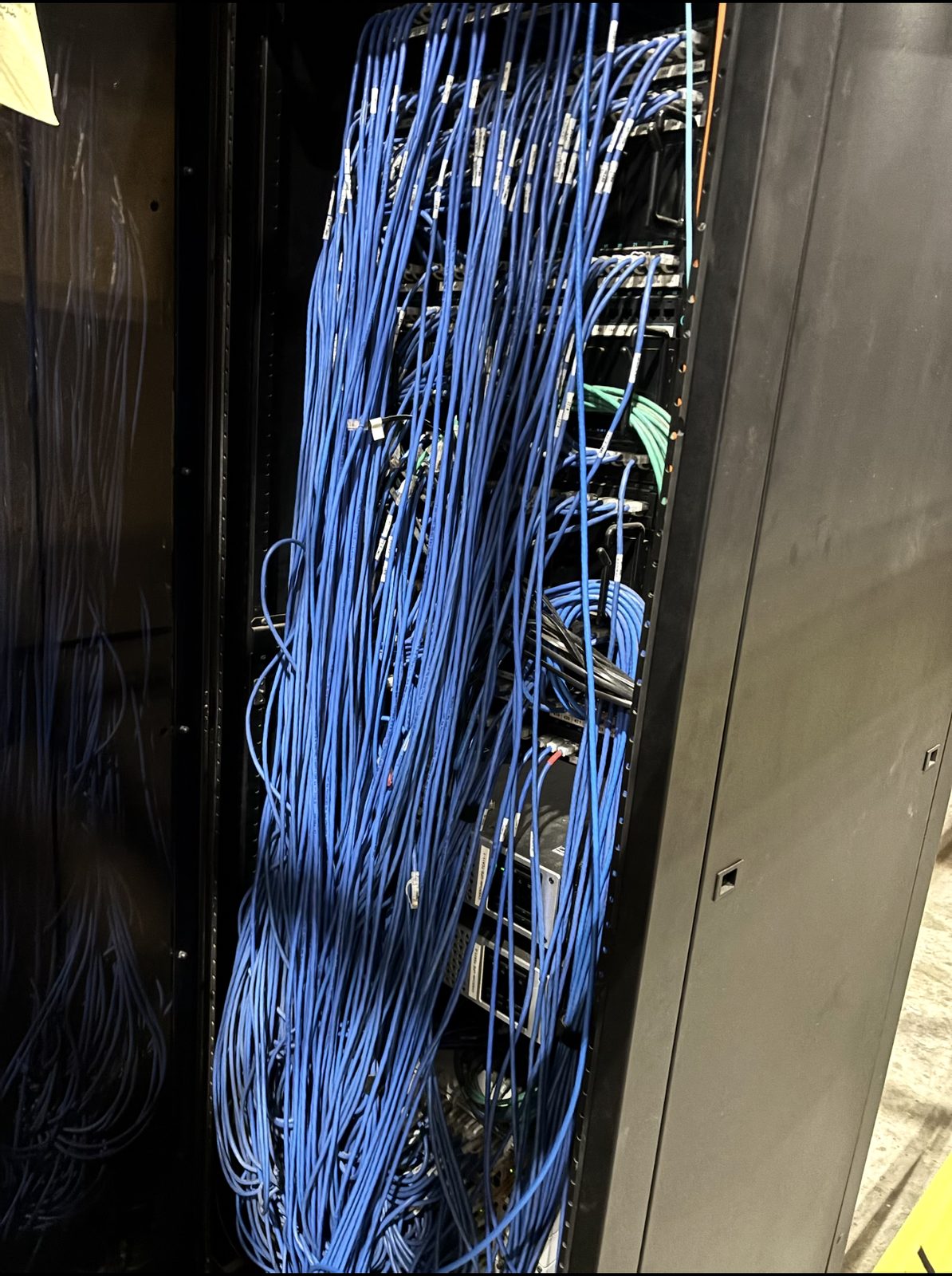 Cascading mass of unmanaged blue patch cords down a rack