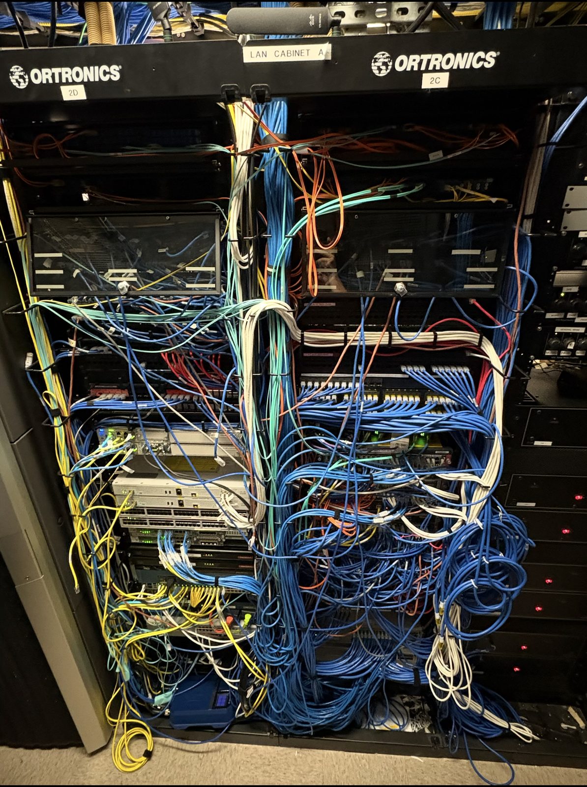 LAN cabinet packed with a chaotic mix of unmanaged cabling