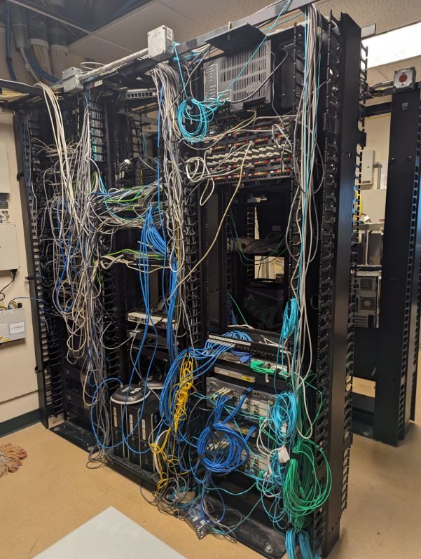 Open rack crowded with tangled, unmanaged copper and fiber