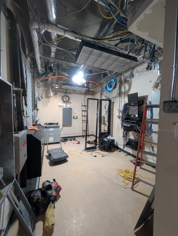 Gutted room during demolition with an empty rack frame and exposed conduit